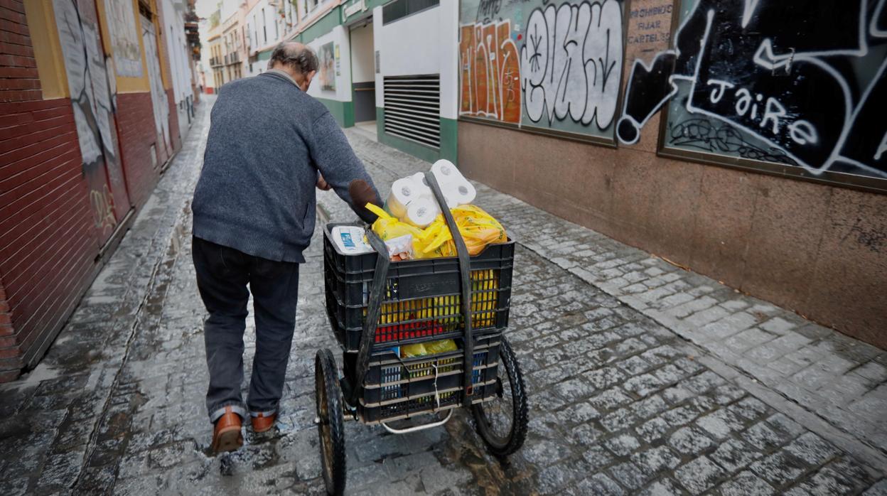 Un vecino de la calle San Luis con el carrito de la compra