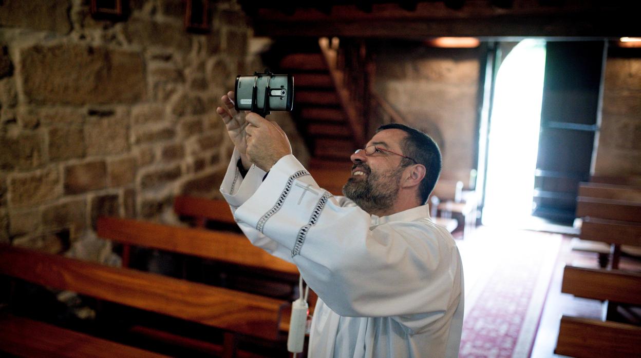 Un sacerdote prepara la cámara para ofrecer la misa en streaming