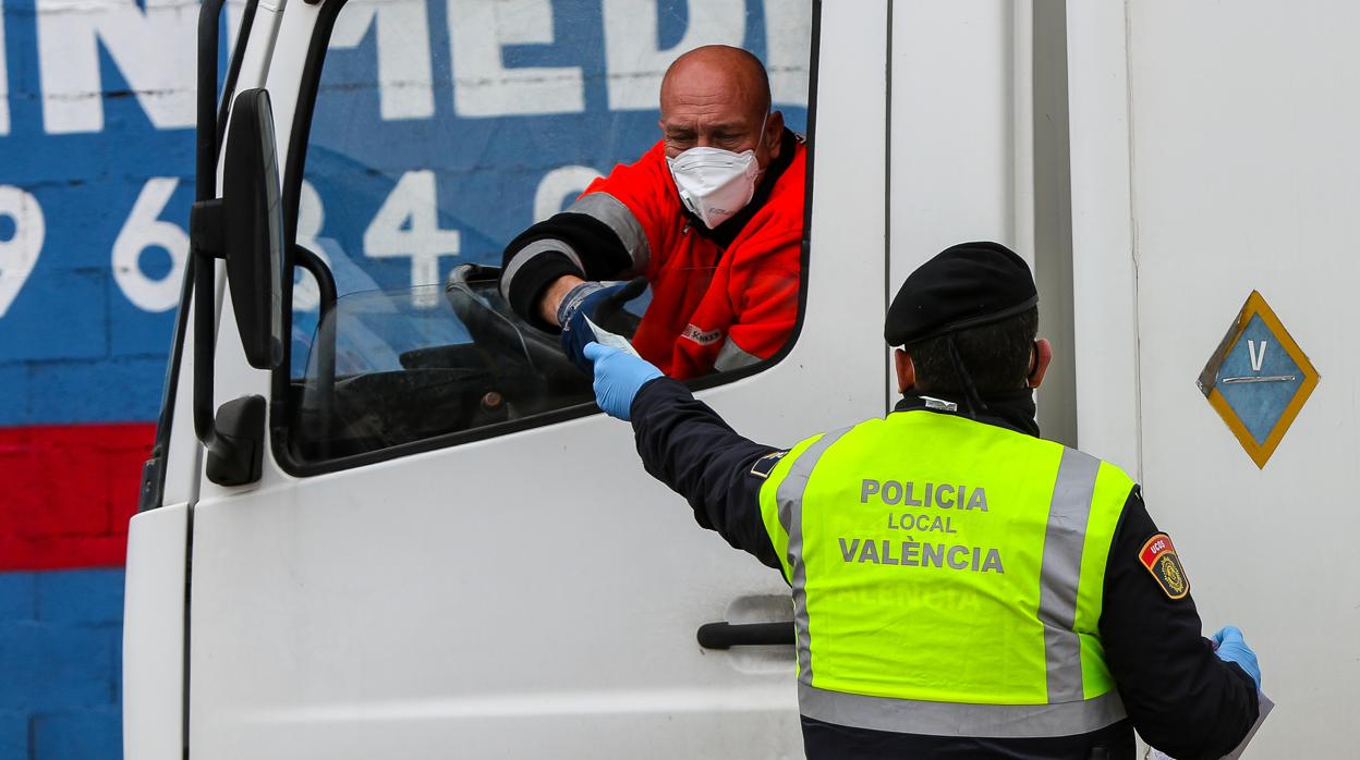 Un transportista junto a un policía local