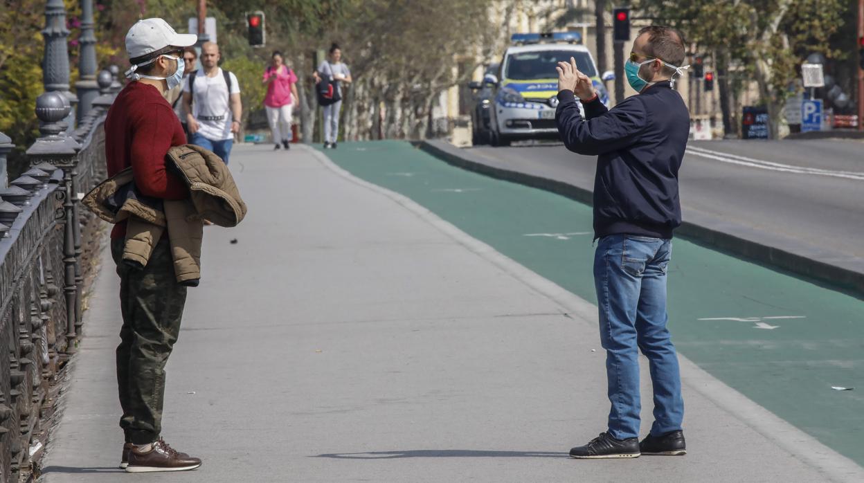 Un turista es fotografiado en el puente de Triana hace un par de semanas