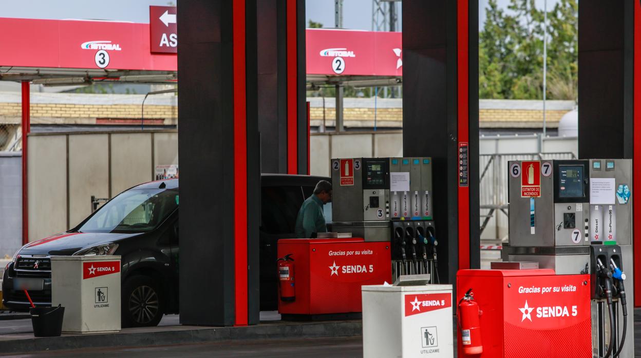 Un conductor repone gasolina en una estación de servicio