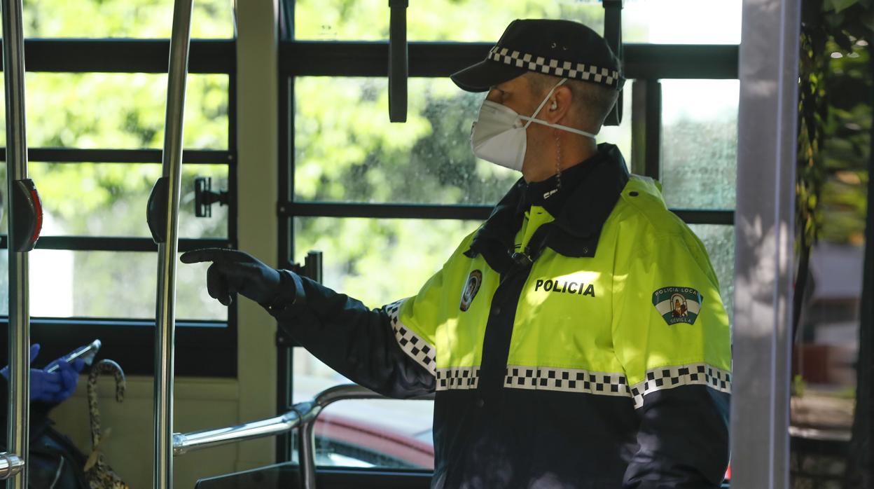 Un agente de la Policía Local de Sevilla durante un control en un autobús urbano