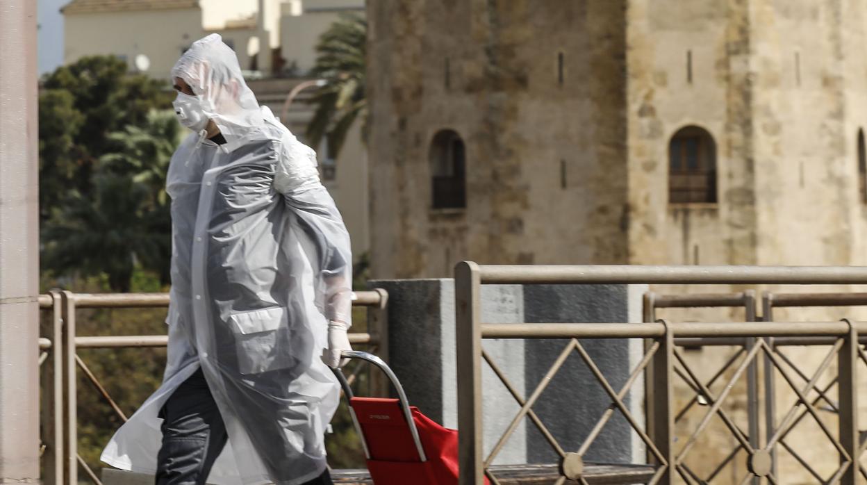 Un hombre pasea por el puente de San Telmo con mascarilla