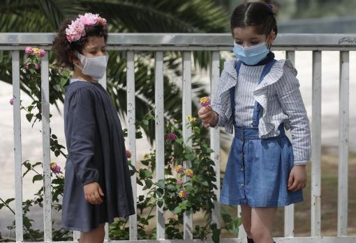 Dos niñas entretenidas con las flores de la lantana