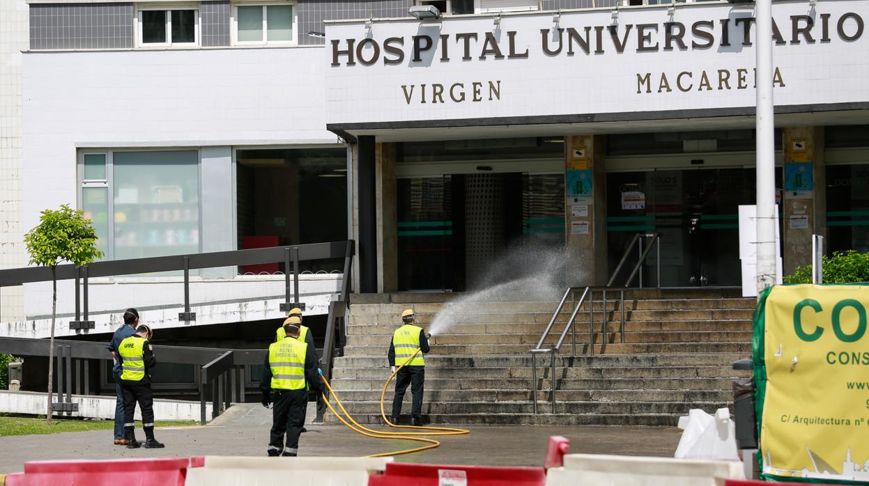 Operarios de la UME fumigan la entrada del hospital Virgen Macarena de Sevilla