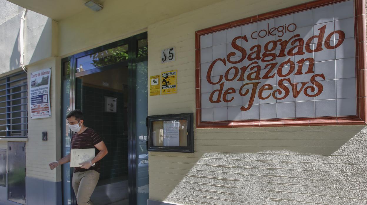 Un hombre sale de un colegio de Sevilla con mascarillas