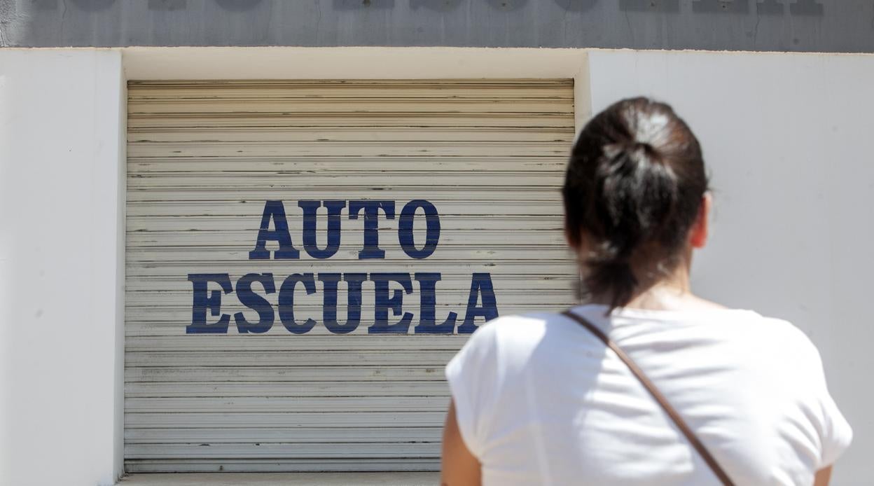 Una alumna delante de una autoescuela cerrada