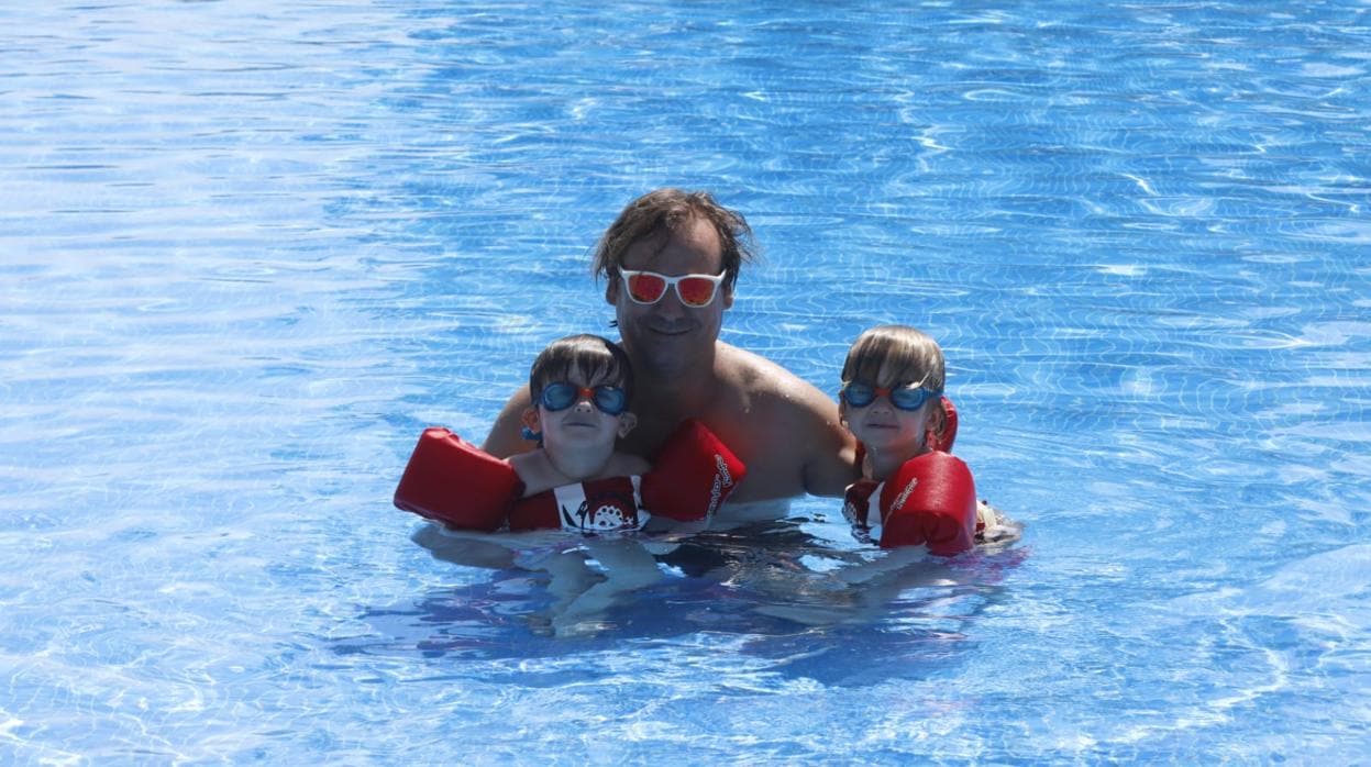 Óscar León con sus mellizos Óscar y Miguel en la piscina del Mercantil
