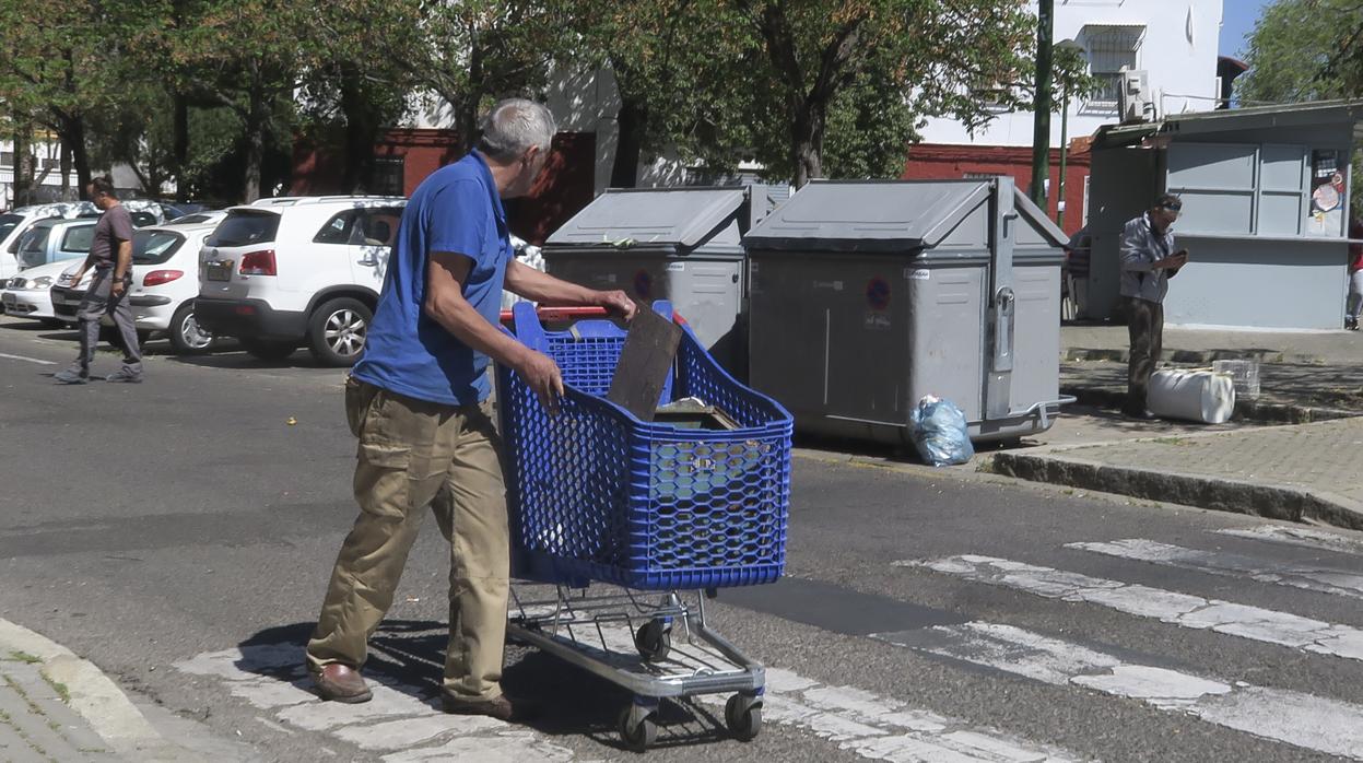 Varias personas recogen utensilios de la calle en el sevillano barrio de Los Pajaritos