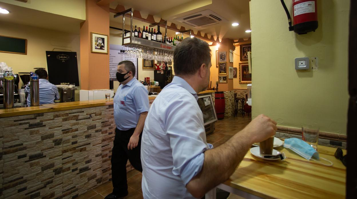 Interior de un bar de Sevilla, con camareros trabajando en la barra