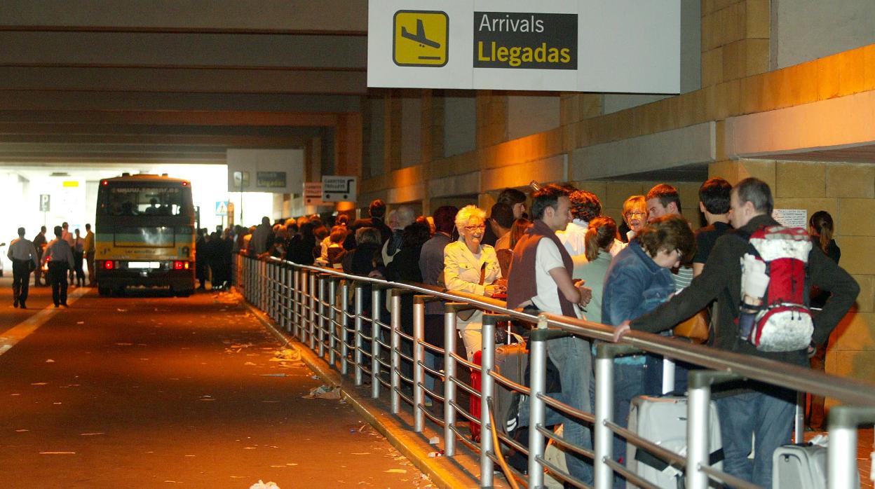 Cola de viajeros esperando el autobús del aeropuerto