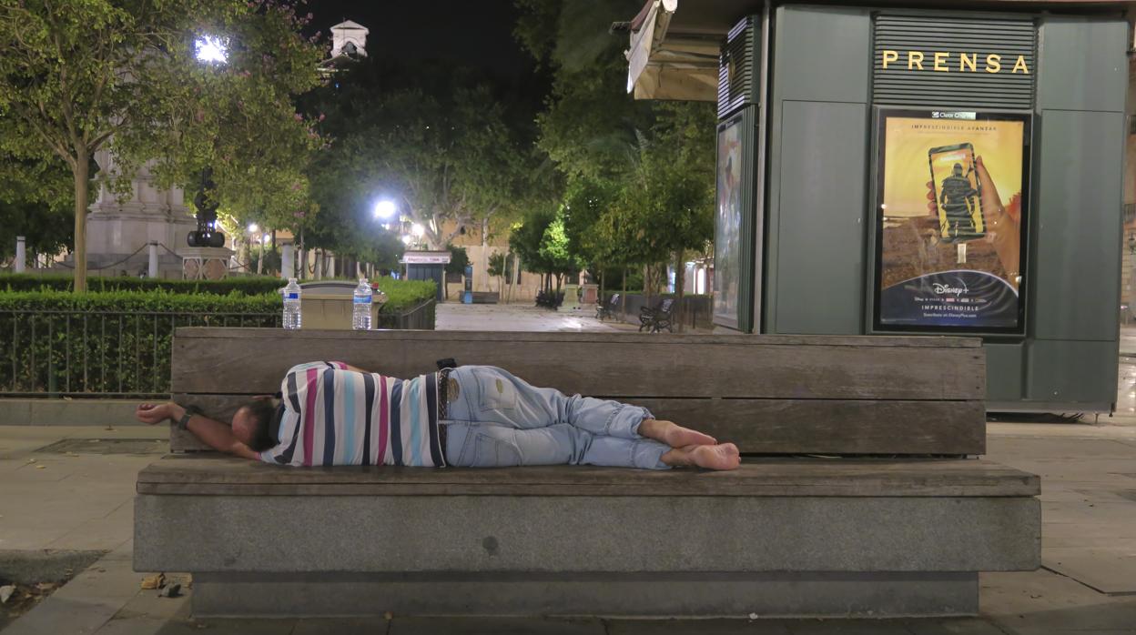 Una persona pasa la noche a la intemperie en un banco de la Plaza Nueva
