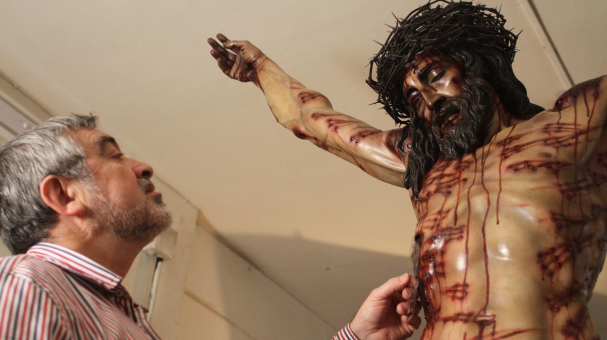 El escultor Juan Manuel Miñarro, junto a su crucificado para la hermandad Universitaria de Córdoba