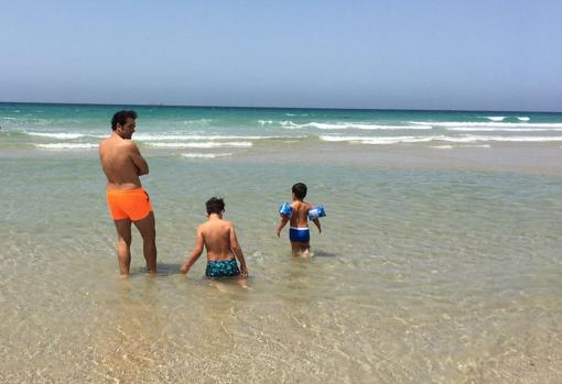 Alfonso Sánchez junto a sus hijos en la playa