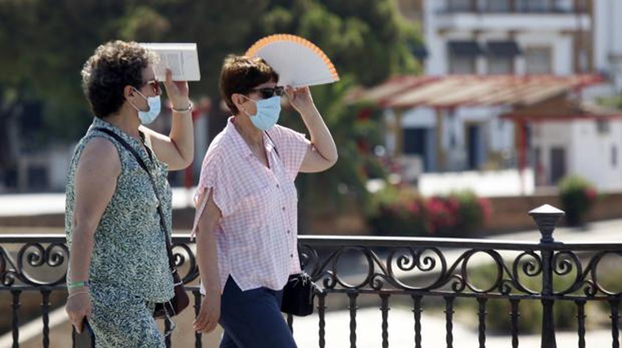 Dos personas se protegen del sol por Sevilla