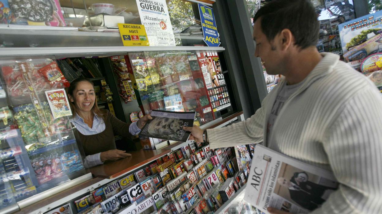 Un cliente compra prensa y revistas en un quiosco de Sevilla