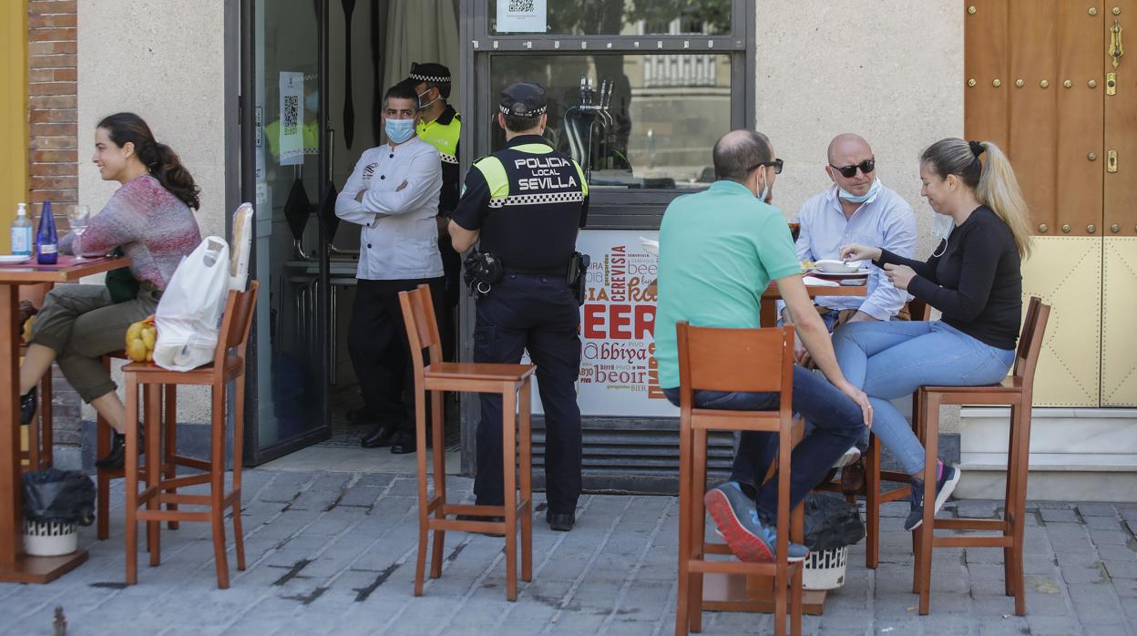 Policía Local repasando las medidas en un bar con veladores de Sevilla