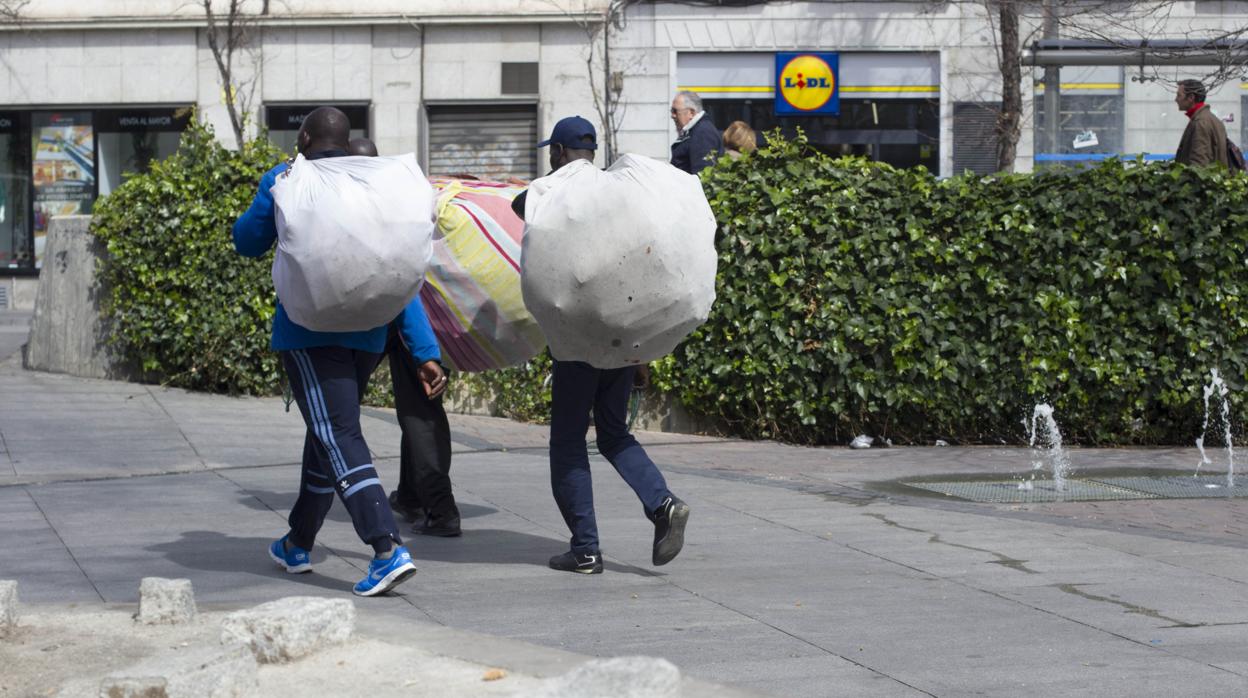 Vendedores del top manta cargan la mercancía