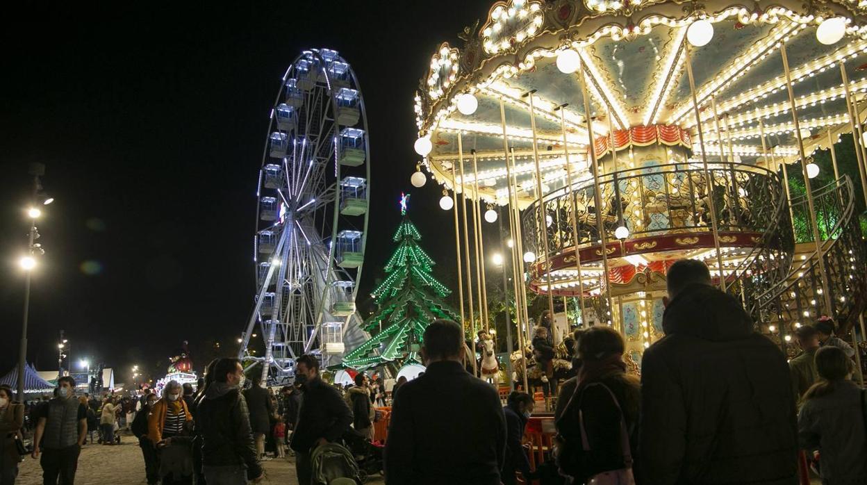 Varios sevillanos disfrutan de las atracciones instaladas al borde del río Guadalquivir