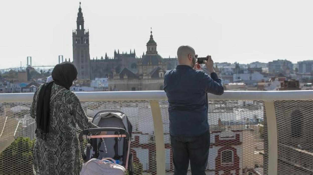 Una familia de turistas fotografía Sevilla desde el mirador de las Setas