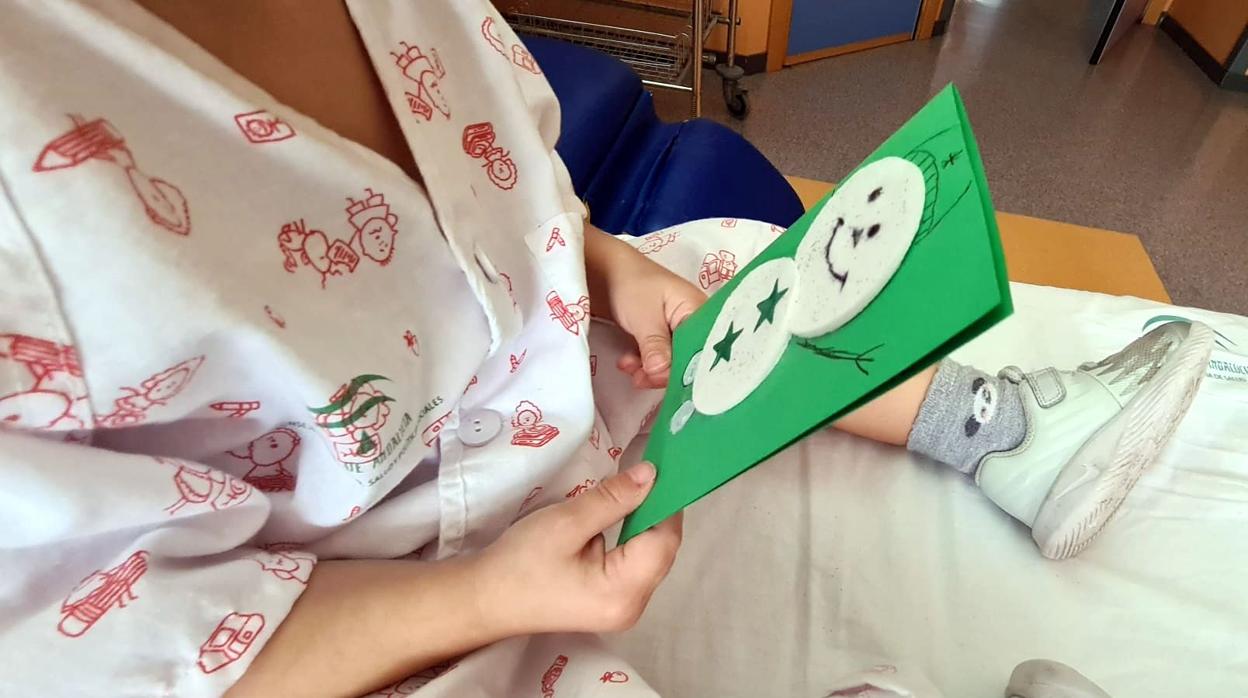 Un pequeño recibe una felicitación navideña durante su estancia hospitalaria en Pediatría del Valme