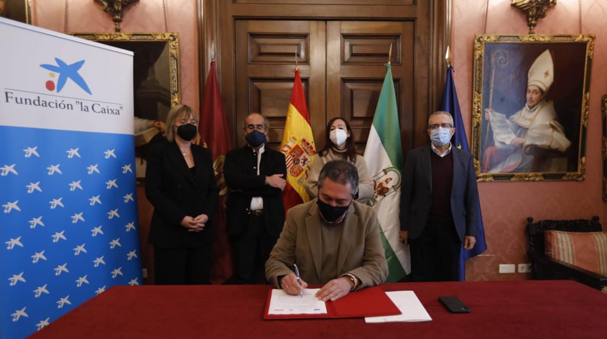 El alcalde, Juan Espadas, firmando el convenio con La Caixa