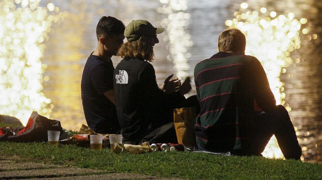 Jóvenes haciendo botellona junto al río Guadalquivir