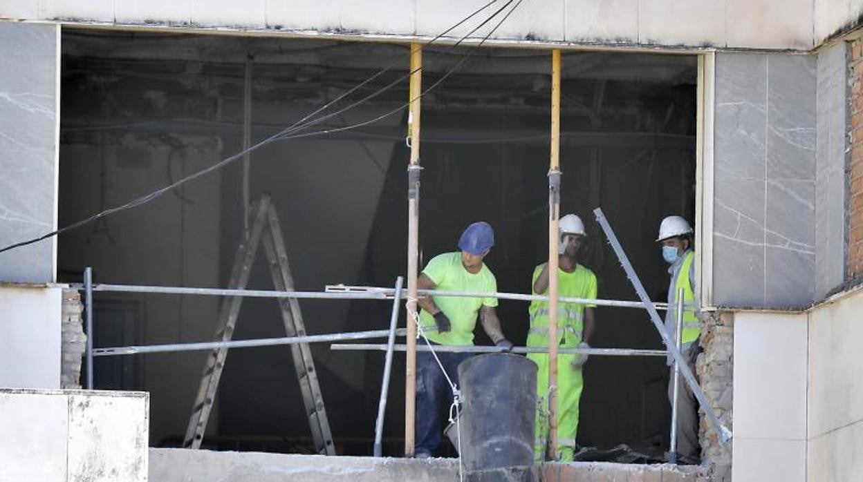 Varios obreros trabajan en un edificio