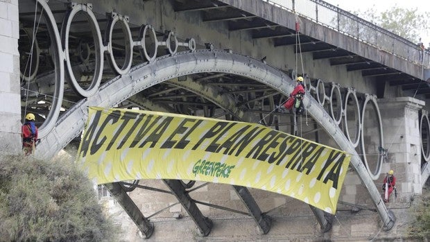 Greenpeace cuelga una enorme pancarta (de lunares) en el puente de Triana en Sevilla