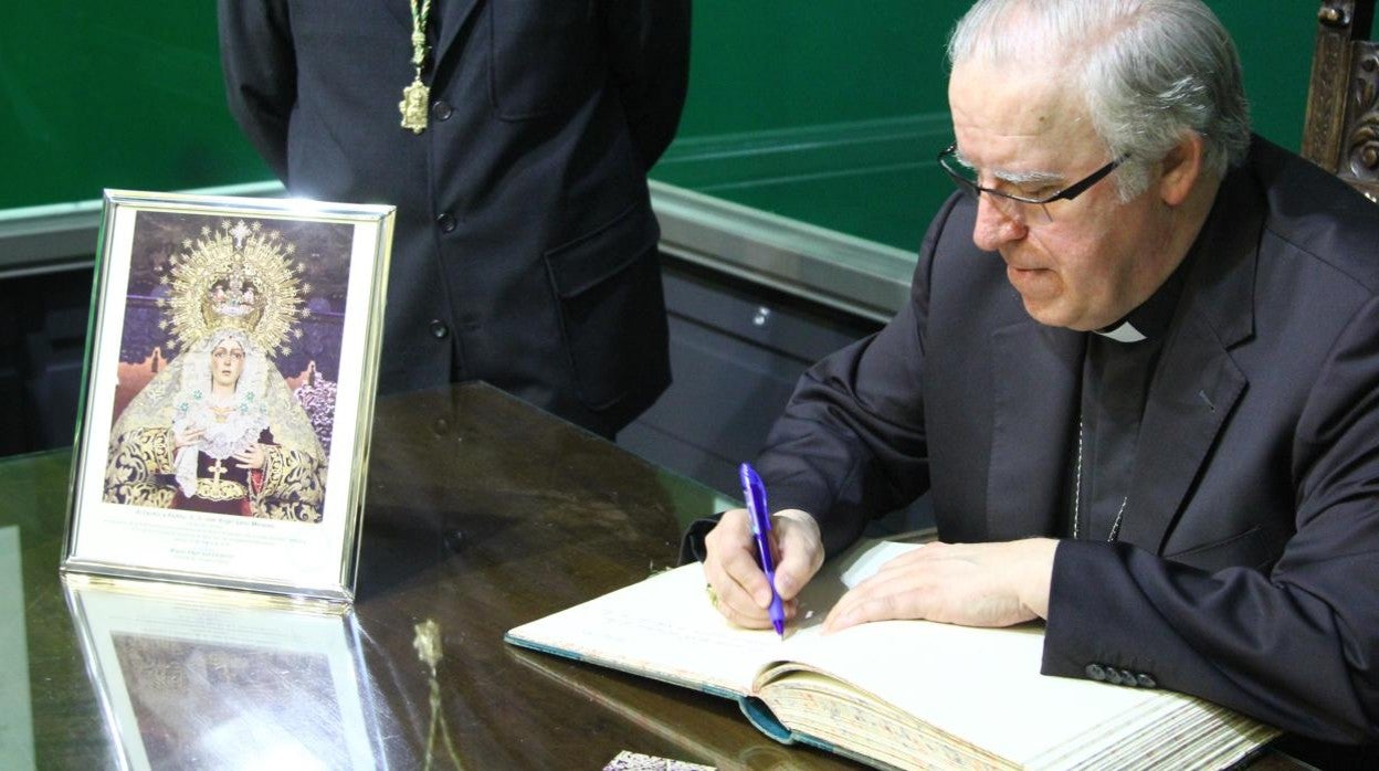 El arzobispo Saiz Meneses firma en el libro de honor de la Macarena