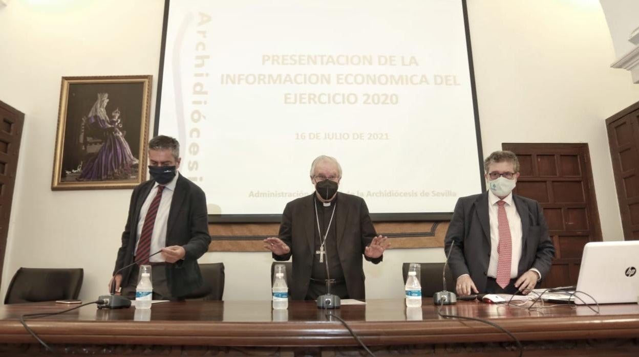 El arzobispo de Sevilla junto al responsable de prensa y el econónomo de la diócesis