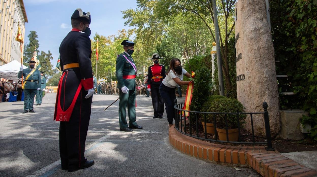 La viuda del guardia Daniel Mesa coloca la corona de flores durante la ofrenda a los caídos