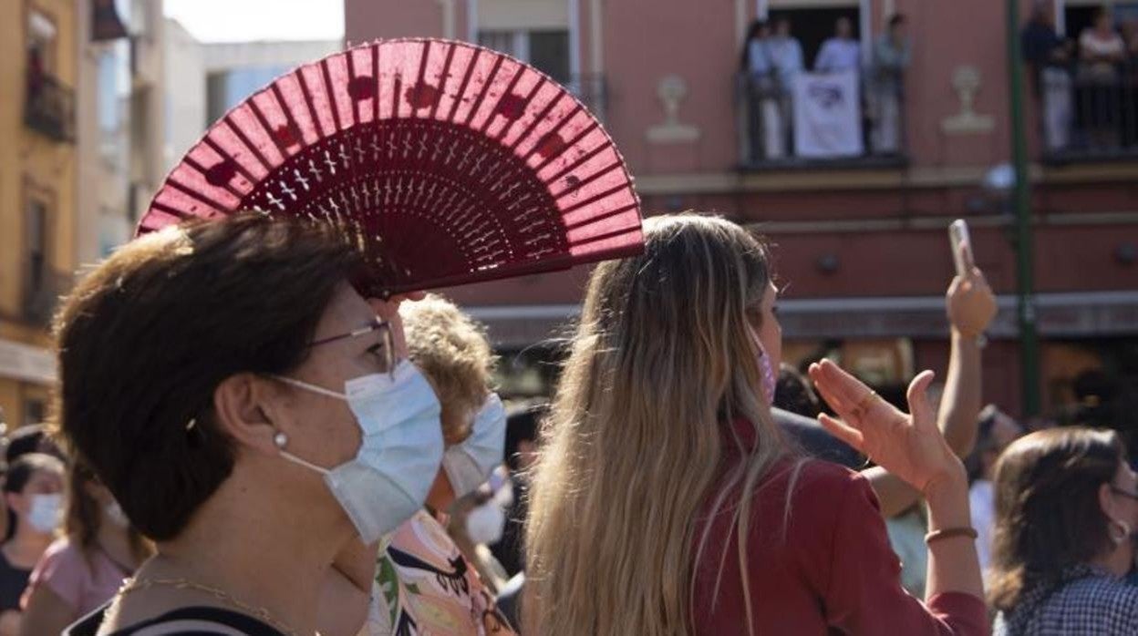 Una mujer se resguarda del sol con su abanico