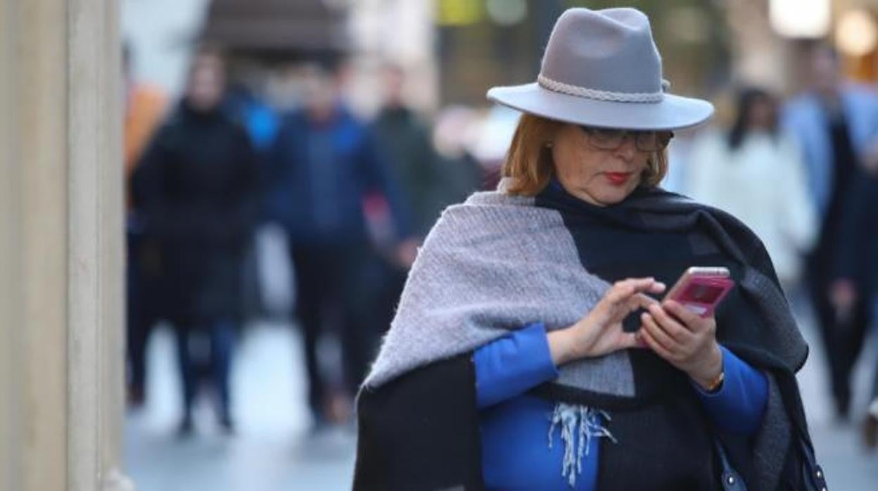 Una señora abrigada pasea por la ciudad