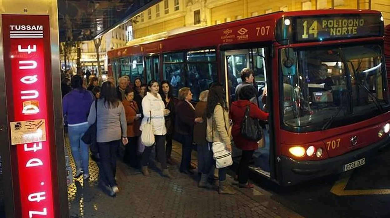 Usuarios subiendo a un autobús de Tussam en la parada de la Plaza del Duque