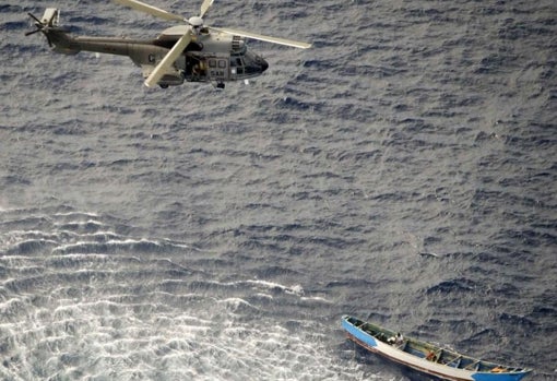 El helicóptero del SAR aproximándose al cayuco con los tres supervivientes