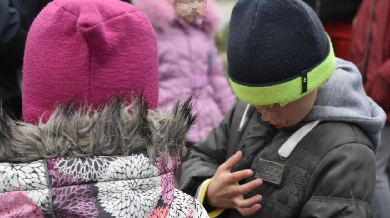 Uno de los niños ucranianos en brazos de uno de los sanitarios en uno de los dos autobuses que los trajeron a España desde Cracovia