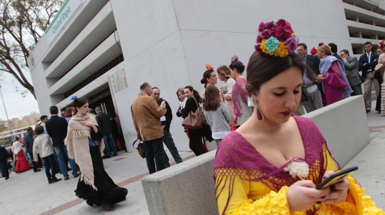 Una joven vestida de flamenca en una de las paradas del metro de Sevilla