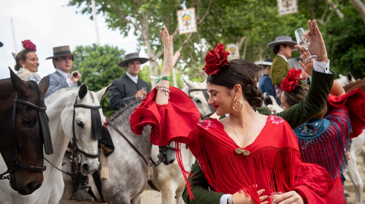 Baile por sevillanas en las calles del real junto a un grupo de caballistas