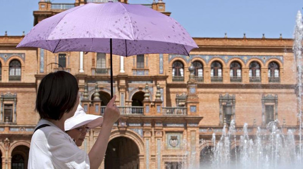 Turistas extranjeros en la Plaza de España de Sevilla bajo un intenso calor