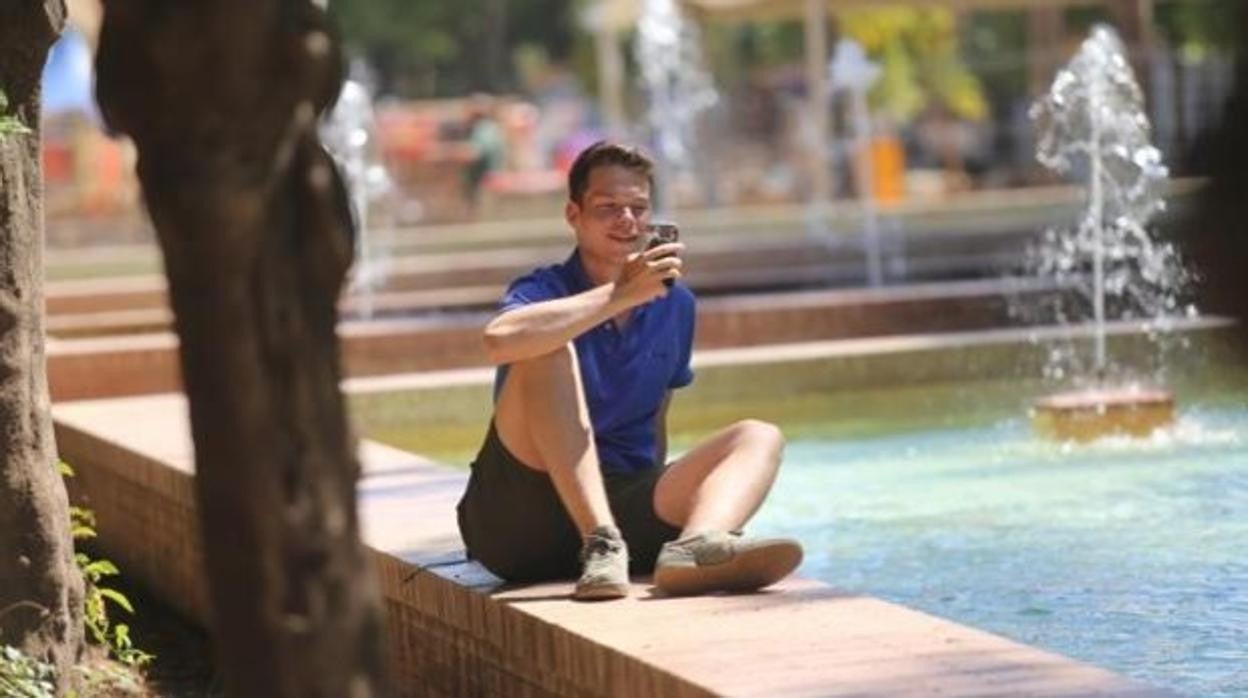 Un joven descansa cerca del agua en el Prado de San Sebastián