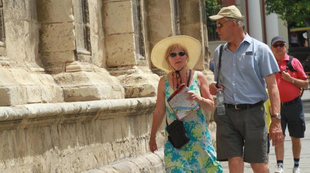 Una pareja de turistas pasea por las calles de Sevilla