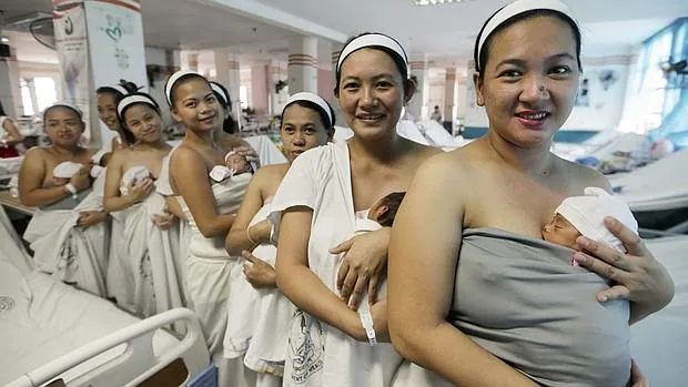 Mujeres sostienen en brazos a sus recién nacidos durante el primer contacto piel con piel, durante una campaña de la Organización Mundial de la Salud (OMS), tras dar a luz en la Maternidad Fabella en Manila (Filipinas)