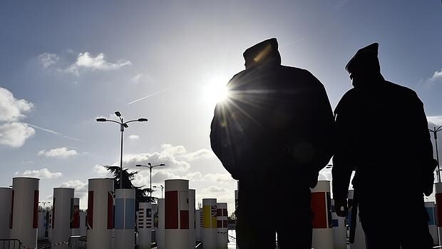 Dos policías franceses hacen guardia frente a la entrada del salón de la COP 21, este jueves