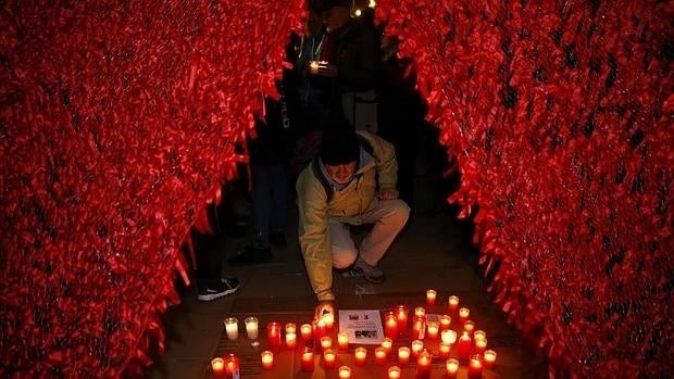 Acto en recuerdo de los fallecidos por sida, en la Puerta de Alcalá de Madrid, celebrado ayer por la tarde