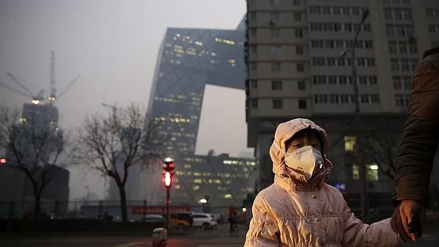 Una niña usa una mascarilla para protegerse de la contaminación ambiental en Pekín (China) este lunes 7 de diciembre