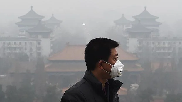 Un hombre se protege en Pekín con una mascarilla en el segundo día de alerta roja por contaminación