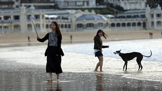 Una turista se fotografía en la playa de La Concha de San Sebastián