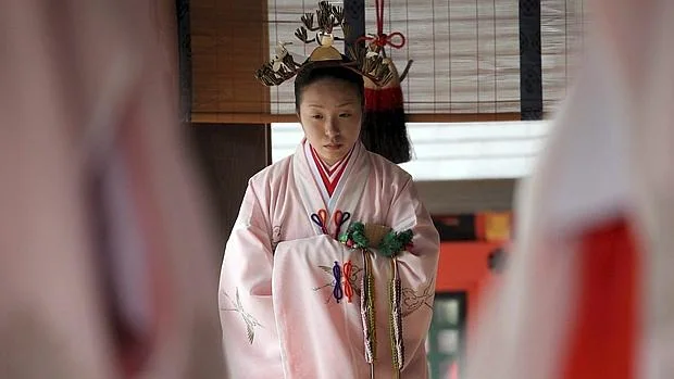 Una mujer japonesa ataviada con el traje tradicional hace una reverencia durante la ceremonia de la recogida de arroz, conocida como «Takaranoichi», en el recinto sagradode Sumiyoshi Shinto, Osaka (Japón)