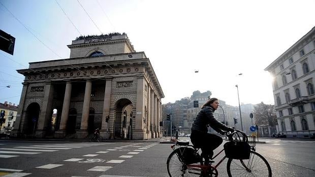 Una mujer pasea en bicicleta por las calles de Milán